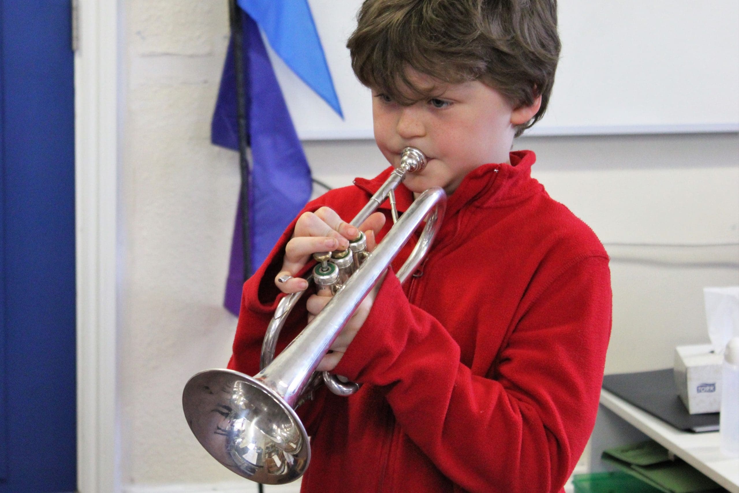 Boy learning to play the trumpet at Music Explorers in Ashford Music Centre