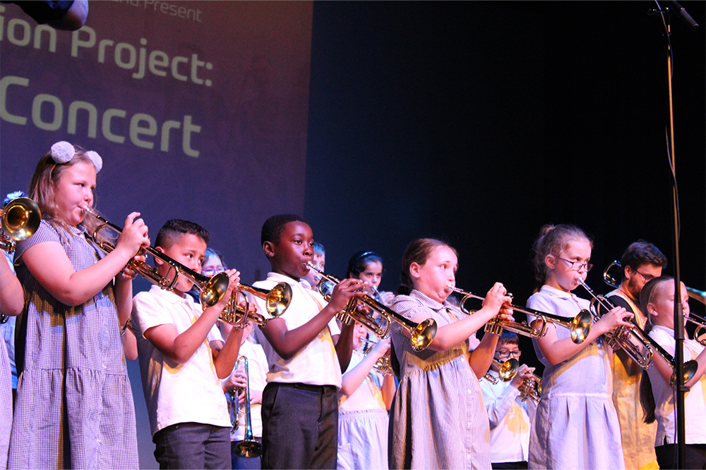 Primary school students playing music together in brass ensemble concert