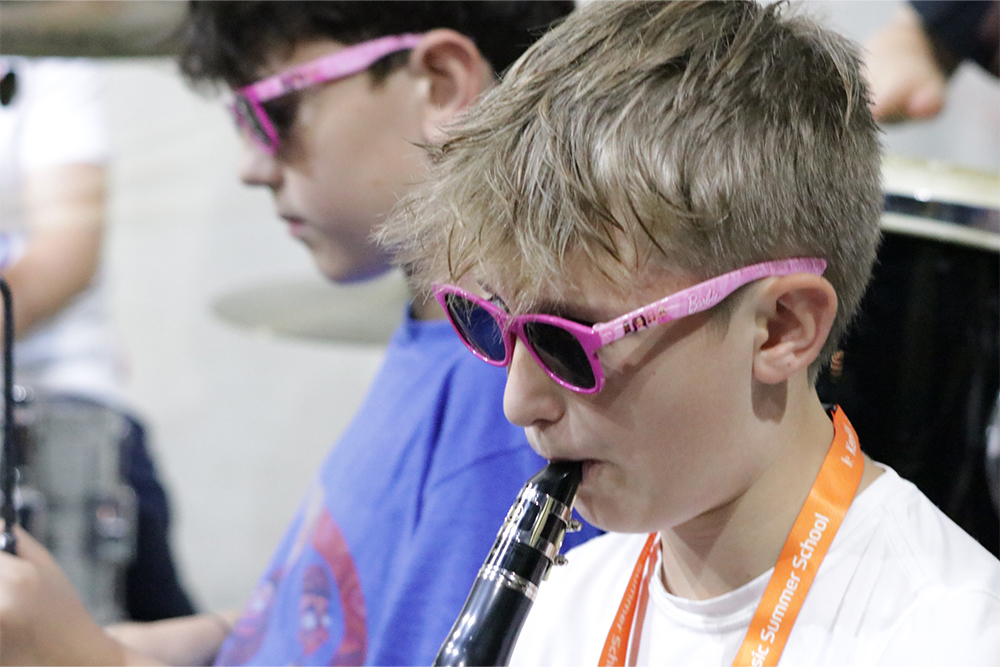 Boy in pink sunglasses playing the clarinet in the Kent Music Summer School Jazz Course