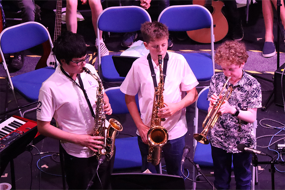 Trio of young musicians performing together playing the saxophone and trumpet in Jazz Course Performance at Kent Music Summer School