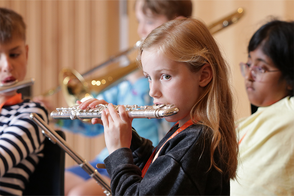 Young girl learning to play the flute