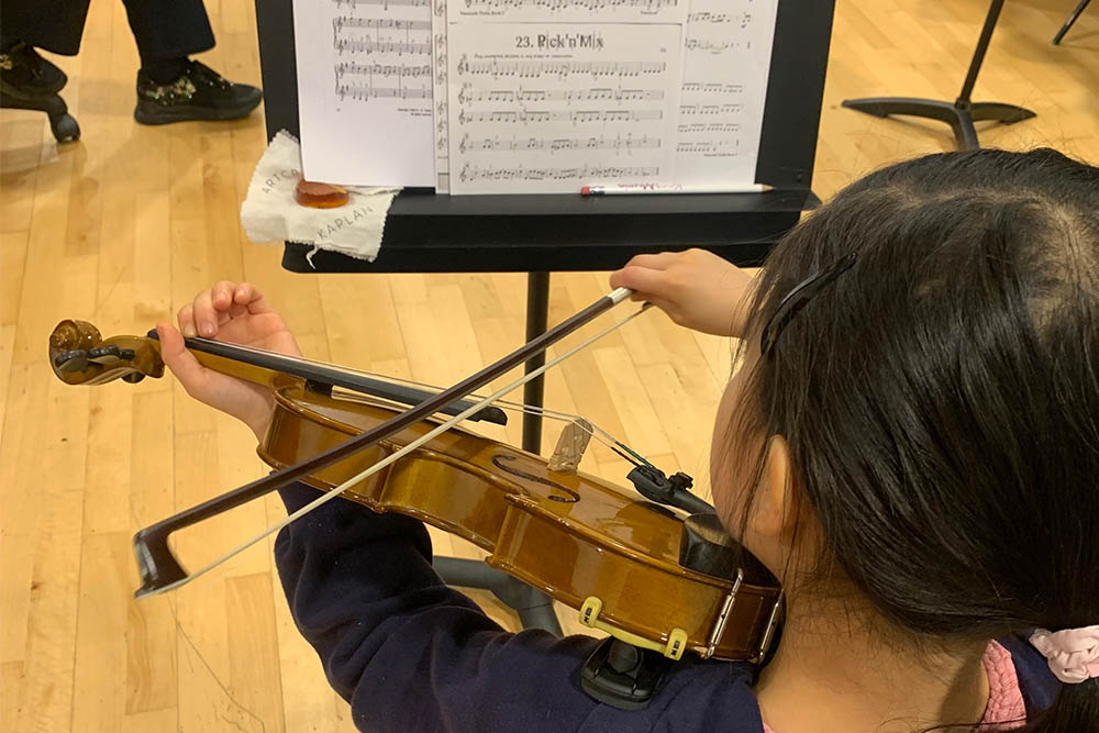 Girl playing the violin, music lessons with Kent Music in local Music Centre