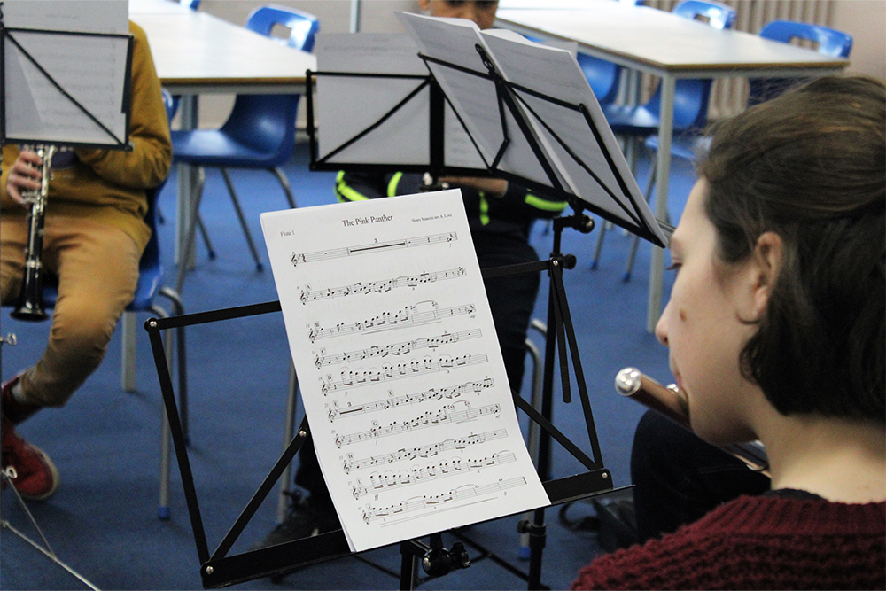 Young flautist learning to play music