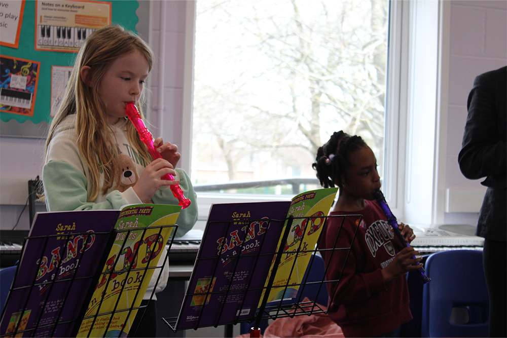 Young girls practicing the recorder together