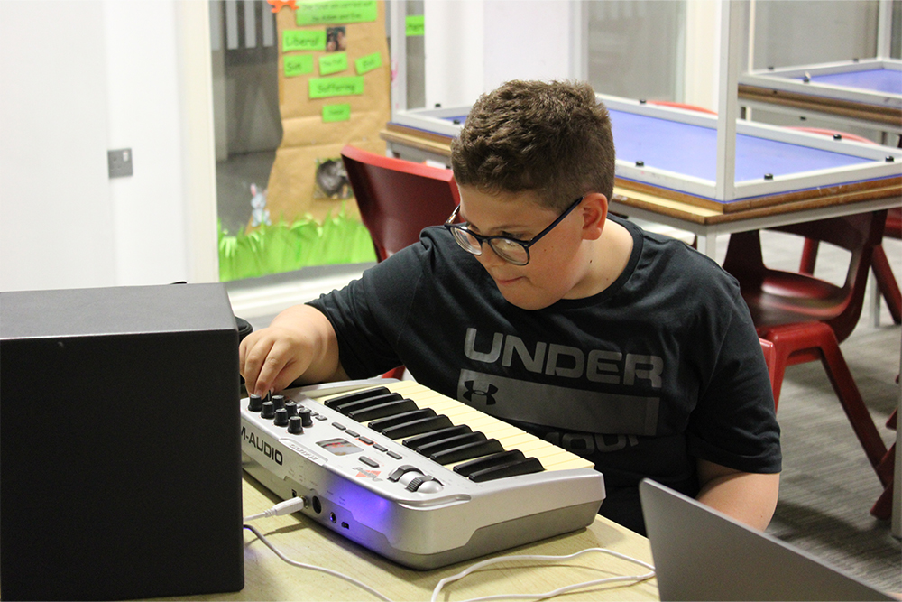 Young boy learning to play music at Thanet Music Centre, Music Lab