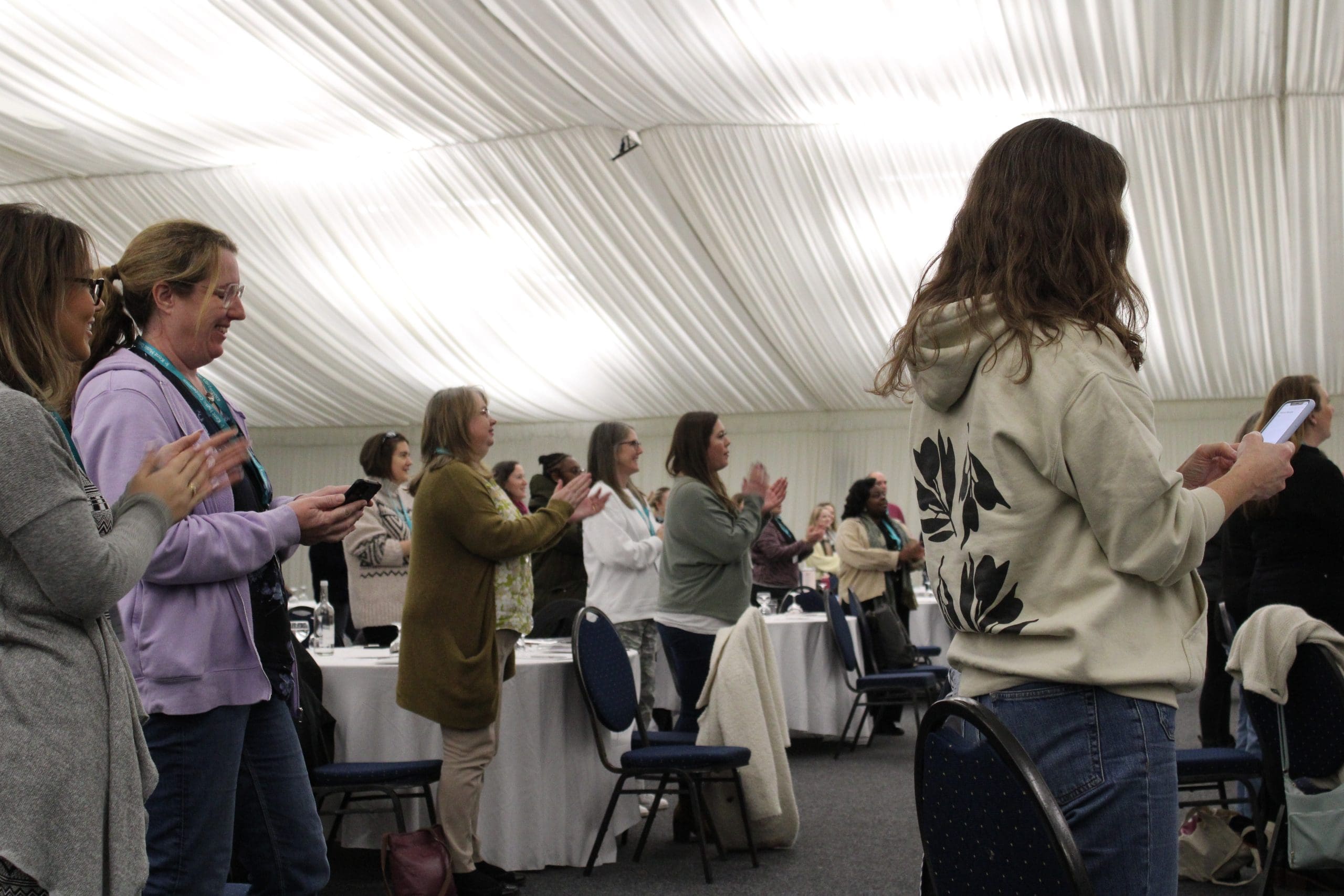 Audience in standing ovation clapping at the Kent and Medway Conference for Kent Music