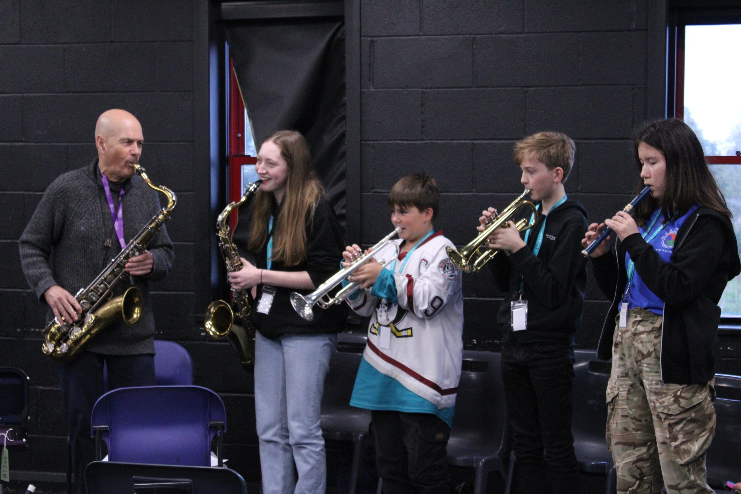 Students having fun playing musical instruments at Orchestra One course